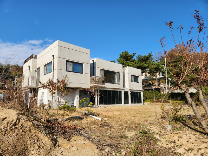 아이보리 색상의 외장 타일 마감과 1층은 폴딩 도어로 개방감을 높인 박스형의 2층 전원 주택