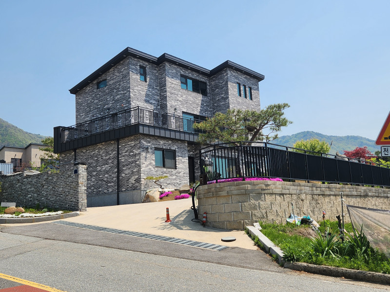 다크 그레이 계열의 벽돌, 쉐드 형태의 징크 지붕 - 전망좋은 집